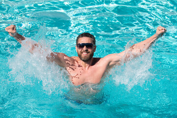 Pool resort. Handsome man in swimmingpool. Guy in water. Spa resort. Summertime vacation. Summer man.