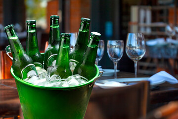 cold bottles of beer in bucket with ice in a restaurant setting © lcrribeiro33@gmail