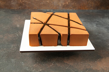 Square design mousse cake with a beautiful top and chocolate coating - side view of the beautiful square modern texture - close-up