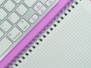 Workplace. Office conception on a pink background. Keyboard and notepad. Flat lay.