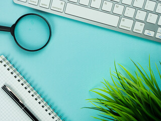 Top view above of magenta workplace with keyboard, paper and pen. Copy space for your text, Flat lay. Office work and office conception.