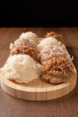 Cocada, Coconut candy from Brazil, white and brown cocadas on wooden surface, black background,...