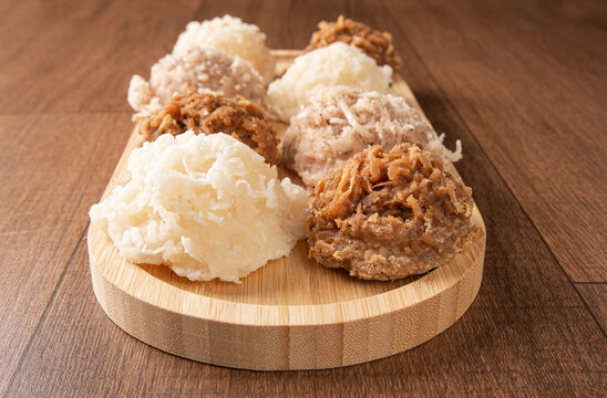 Cocada, Coconut candy from Brazil, white and brown cocadas on wooden surface, black background, selective focus.