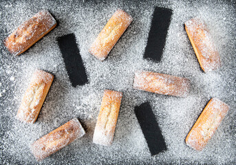 Christmas dessert - pastries from France financier cake on a black background with icing sugar...