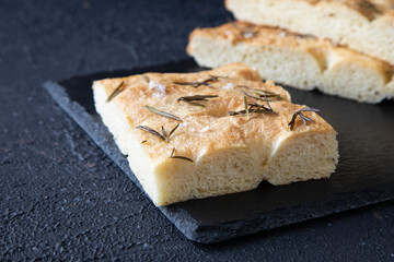 Delicious focaccia - Italian bread - according to a traditional recipe consisting of flour, olive oil, water, yeast, Fleur de Sel, sugar, rosemary