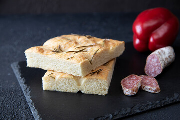 Focaccia - traditional Spanish food with salami sausage, and red pepper on a blackboard for lunch or dinner