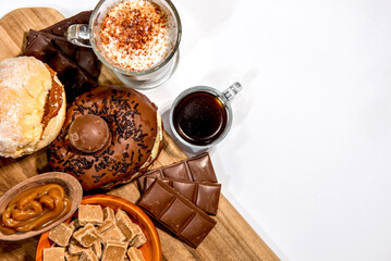 Wooden board with donuts, chocolate, coffee and moccha. Top view.