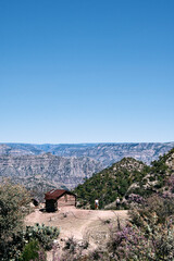 Drewniana chata na tle gór. Copper Canyon z osadą tarahumara (raramuri) - obrazy, fototapety, plakaty