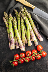 Fresh raw uncooked green asparagus and cherry tomatoes.