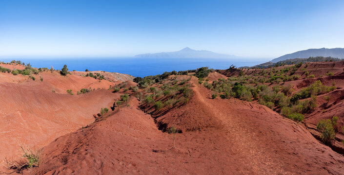 La Gomera, oberhalb von Agulo - Wanderweg zum Mirador de Abrante durch die Landschaft aus roter Erde mit Blick zur Insel Teneriffa