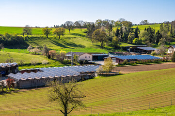 Frühlingslandschaft mit modernem Aussiedlerhof mit Solardächern 