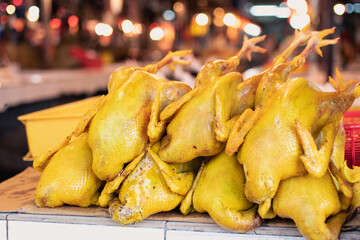 Bunch of cooked ducks on counter at market stall in Kuala Lumpur in Malaysia. Low light, soft focus.