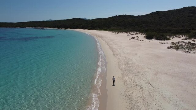 Un Ragazzo corre in una lunga e bellissima spiaggia della Sardegna