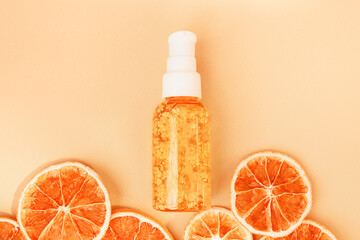 Orange moisturizing serum with essential oils for facial scin care. Transparent glass pump bottle...