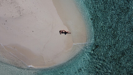 Mature lady on vacation laying on a tropical beach