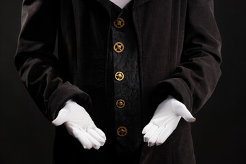 Hand gestures. Showman or magician illusionist in white gloves on a black background.