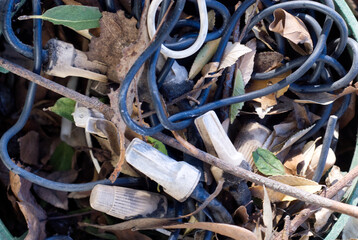 Capped wires surrounded by dry sticks and leaves.