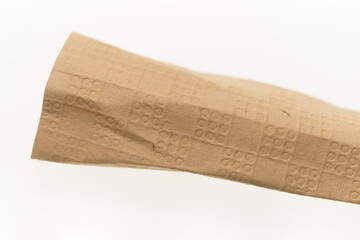 isolated crumpled or folded brown textured and patterned paper on white