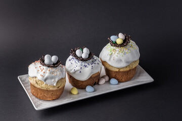 several traditional Easter cakes and candy eggs on dark background decorated homemade pastry top view