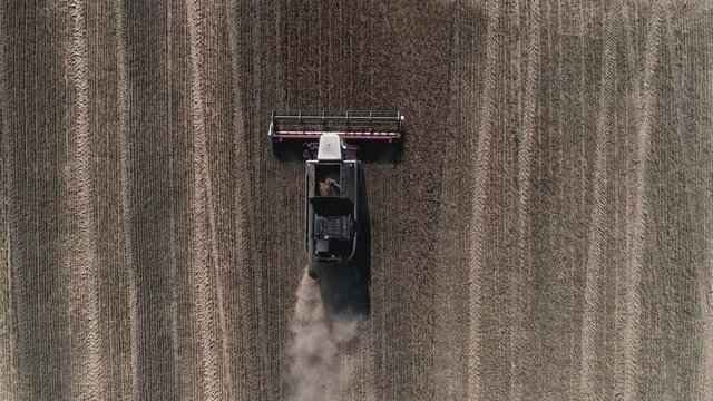 Flying over the harvester driving across the field