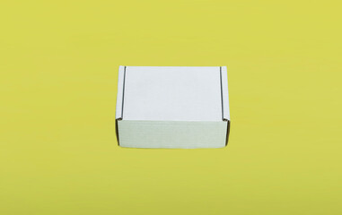 mockup of a white cardboard box on a yellow background. space for text