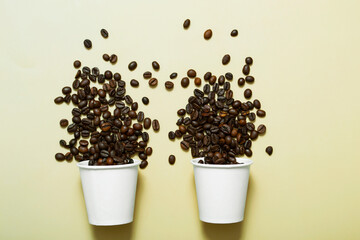 Fototapeta na wymiar Mock up paper white glass with coffee beans on a beige background. Two paper cups