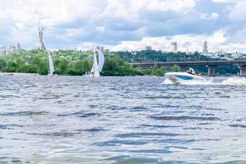 Luxury sailing yachts witn motor boat in bay on river or lake. bright sky with clouds on summer...