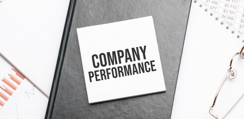 Notepad with text COMPANY PERFORMANCE on a charts and numbers. Business concept.