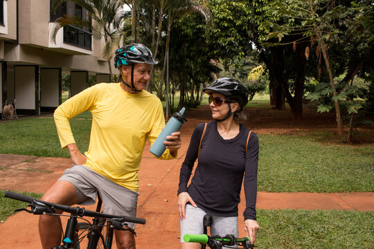 Mature Couple Outdoors In An Urban Area On Their Bikes