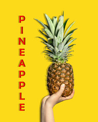 A large pineapple in a woman's hand. Fresh pineapple on a yellow background. Exotic fruits.