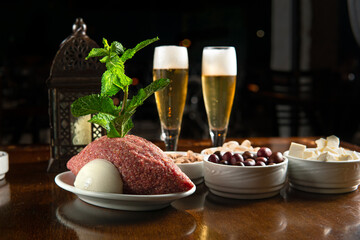Traditional Middle Eastern food. Lebanese food. Arabian raw kibbeh, olives, cheese, beer glass