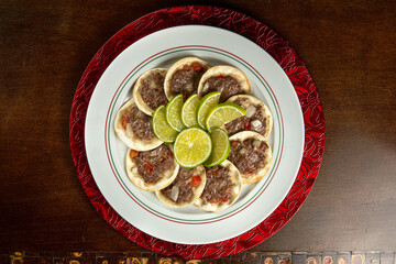 Traditional Middle Eastern food. Lebanese Sfiha meat. Arabian sfeeha plate. Esfiha with lemons on a wood base. Top view