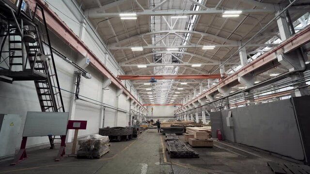 Inside huge industrial factory workshop interior with stacks of wood for making molds.