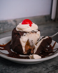 Delicioso helado de americana con chocolate y una fresa cortado con cuchara