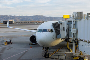 Parking at terminal gate passenger aircraft at the connected bridge is loaded with luggage
