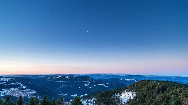 Time-lapse, moon disappears and sunrise illuminates Feldberg (Black Forest) in Germany.