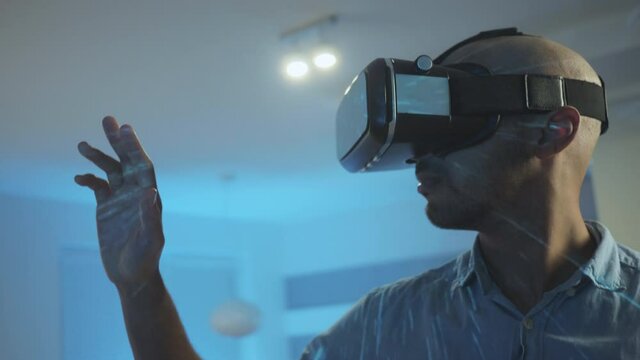 Close up of an African-American man with VR glasses, trying to touch VR objects with an open hand