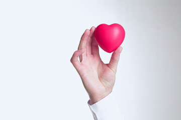 Doctor holding heart in his hands on white background