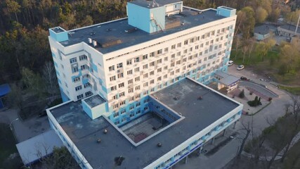 Hospital building exterior on a sunny day. Aerial side view of a clinic windows at sunset