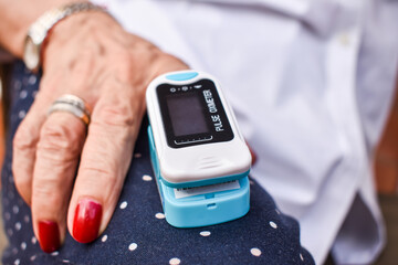 Mature Woman Checking Oxygen Saturation with Oximeter