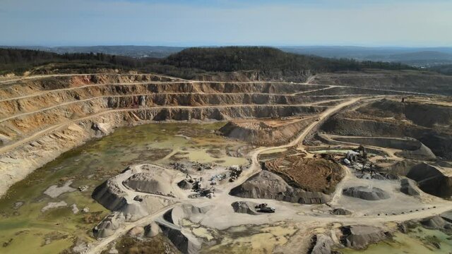 An open-pit mine surrounded with green forest. Limestone production.
