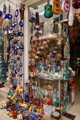Naklejka premium Bodrum, Turkey - August, 2020: Atmospheric local souvenir markets. Turkish Grand Bazaar. Hand-made souvenirs at street market. Souvenirs: wind music, dream catcher, evil eye keychain, beads, bracelets