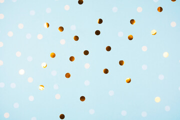 Festive light blue background with golden confetti