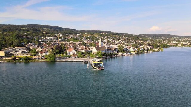 Aerial drone shot rotating around car ferry at Meilen in Switzerland