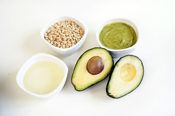 Organic fresh green avocado with avocado oil, pine nuts and avocado guacamole white background