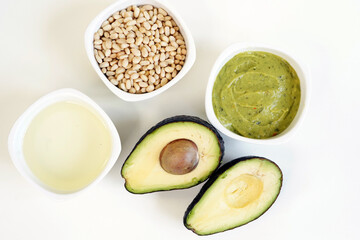 Organic fresh green avocado with avocado oil, pine nuts and avocado guacamole white background