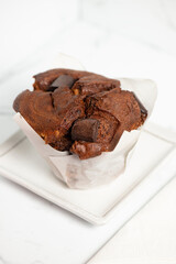 Freshly baked extra large chocolate muffin on a white background.