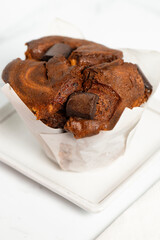 Freshly baked extra large chocolate muffin on a white background.