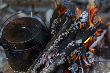 Far Eastern nature. Close-up. Tourist bowler hat stands on the fire. Cooking tourist soup over the...