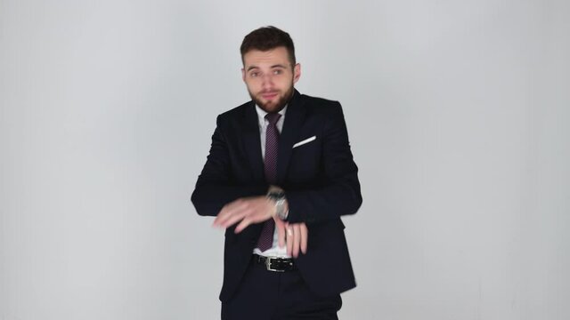 Young handsome businessman in suit dancing, isolated, grey background